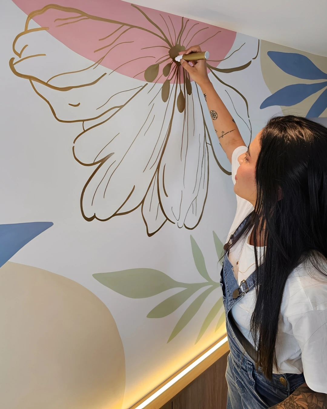 Professora pintando uma flor orgânica em uma parede